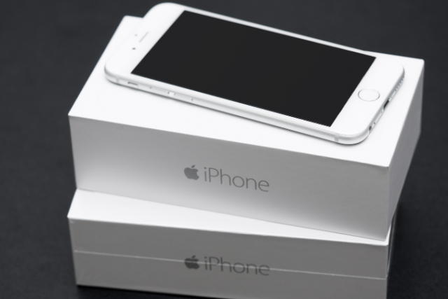 A close up of an iphone and its packaging to show how the packaging is just as important as the product.